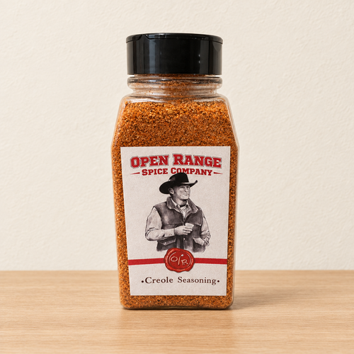 Open Range Creole Seasoning jar on a light oak shelf against a cream wall